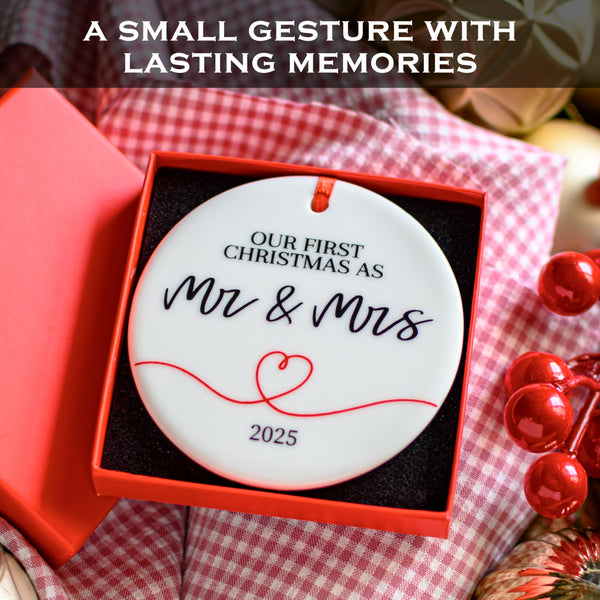 Christmas ornament in a red box with 'Our First Christmas as Mr & Mrs 2025' text on a checkered fabric background.