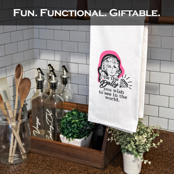 Kitchen towel with graphic design hanging on a towel rack with kitchen items in the background.
