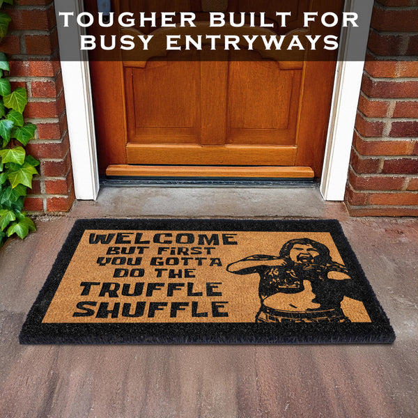 Doormat with humorous design and text in front of a wooden door.