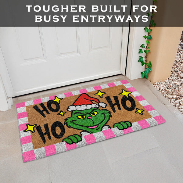Christmas-themed doormat with a cartoon character and 'Ho Ho Ho' text on a gray floor.