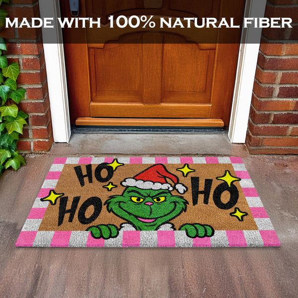 Christmas-themed doormat with Grinch design on a wooden floor.