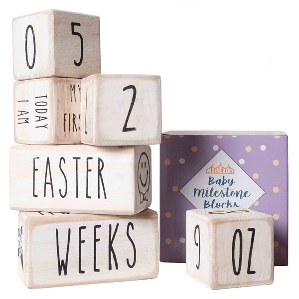 A set of wooden blocks with numbers and words printed on them, used as a baby milestone prop, displayed alongside its packaging box.