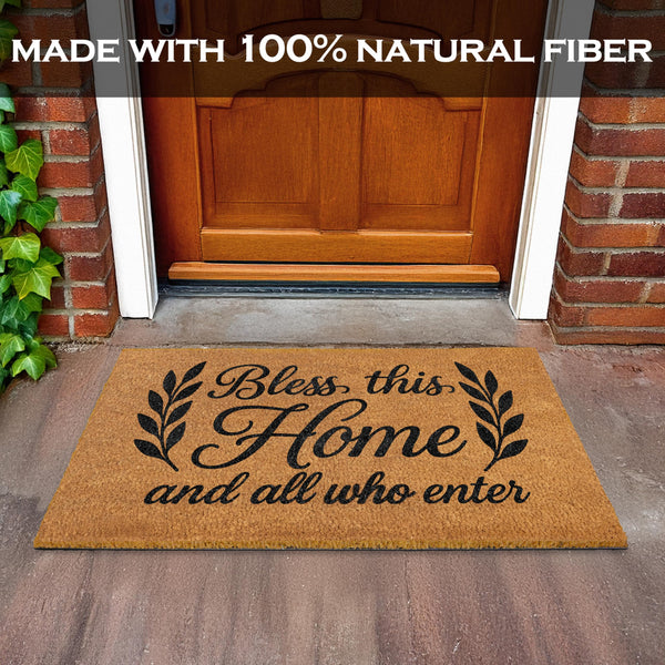 Doormat with 'Bless this Home and all who enter' text on a wooden floor in front of a door.
