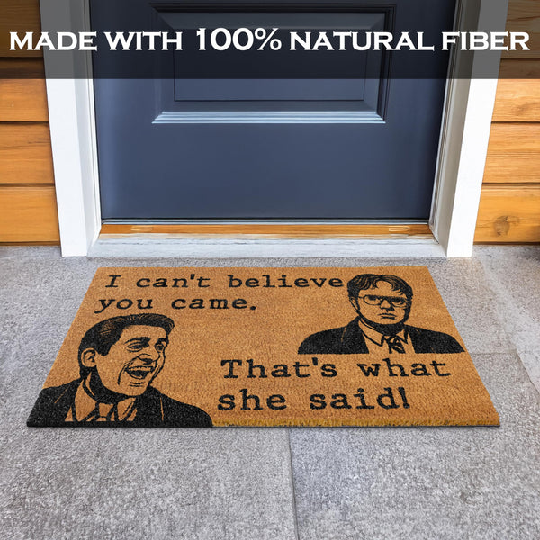 Doormat with humorous quote in front of a blue door, labeled 'Made with 100% natural fiber'.