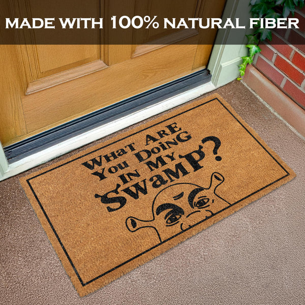 Doormat with humorous text and graphic on a carpeted floor, featuring a door in the background.