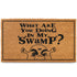 Doormat with text 'What Are You Doing In My Swamp?' and a cartoon character's face.